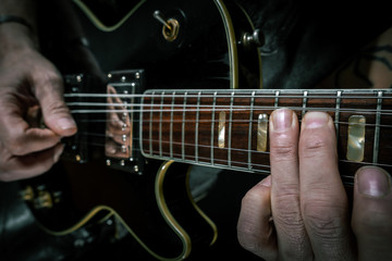 Obraz na płótnie Canvas Guitar player bending black Les Paul like a rockstar