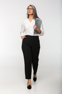Image of adult mature woman wearing office clothes holding clipboard