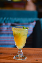 Cider, mulled wine made from white wine in a glass on a wooden table with blurred background.