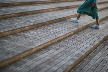 girl in white sneakers and pants walking on the stairs on the street