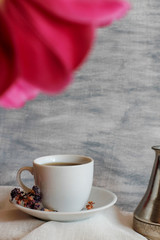 cup with coffee and pink tulip