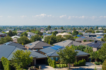 Fototapeta na wymiar Aerial view of residential houses in Melbourne's suburb. Elevated view of Australian homes against blue sky. Copy space for text. Point Cook, VIC Australia.