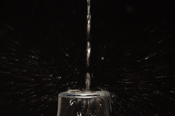 Naklejka na ściany i meble Drinking water falling in a glass