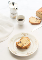 Fetta di banana bread su piatto bianco e dorato, sfondo bianco