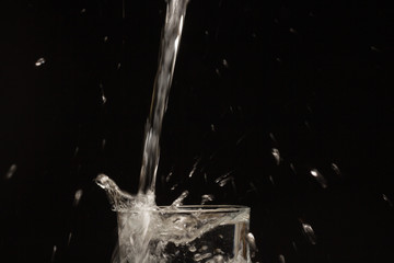 Drinking water falling in a glass