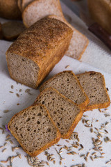 Whole- grain rye bread on a tree with wheat grains. Dietary product of proper nutrition