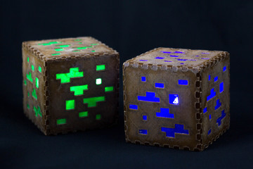 Fototapeta premium Minecraft cubes made of plastic. Two brown minecraft cubes with glowing Windows