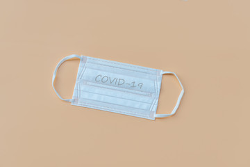 Top view of protective mask on orange background, flat lay and copy space. Health care concept.