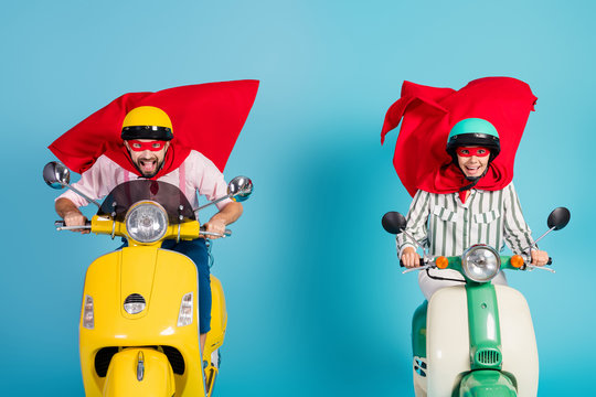 Photo of cool lady guy drive ride two retro moped wear red cape mask protective hats rushing road halloween party play super heroes role coat flying air isolated blue color background