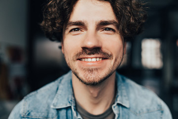 perfect smile. Attractive and handsome unshaved young guy smiling to a camera