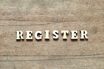 Letter block in word register on wood background