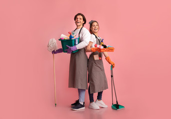 Happy young couple with lots of detergents posing over pink background