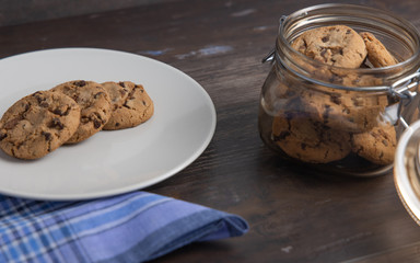 Chocolate cookie jar on rustic wooden background and blue napkin
