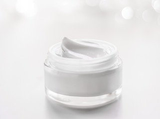 Facial cream moisturizer jar on holiday glitter background, anti-age skin care product