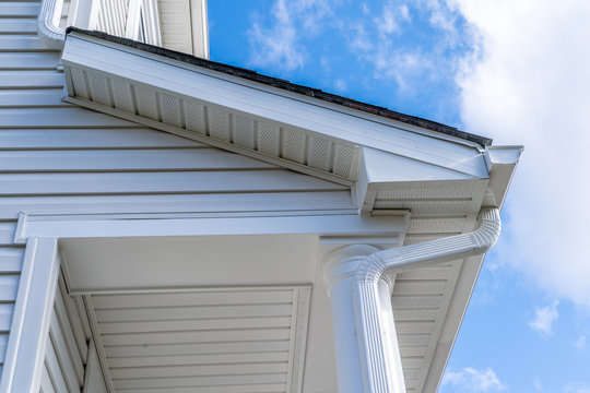 Classic white gutter system that collects water shedding off the roof, with slip connector, end cap, elbow tube, gutter hanger, gutter drop connecting  the outlet to the downspout with soffit, fascia