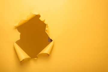 torn hole in yellow paper texture with copy space - obrazy, fototapety, plakaty