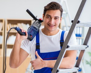 Repairman working with drilling drill perforator