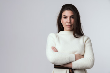 Brunette woman in white sweater posing isolated.