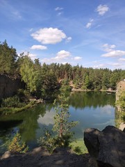 Fototapeta na wymiar quarry with a lake in the forest