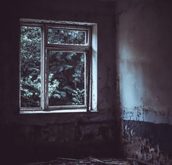 Dark room in an abandoned ruined building. Light from a window