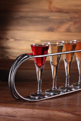 Closeup Set of colourfull alcoholic cocktails in shot glasses on wooden table.