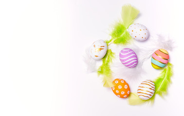 Creative Easter holiday layout eggs colored handmade paint ed with feather on white background.Seasonal flat lay concept.