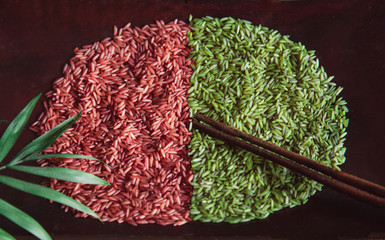 Red and green rice on wooden plate