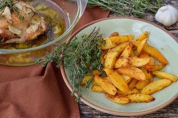 Roasted chicken thighs with olive oil, garlic and rosemary. Served with baked potato wedges