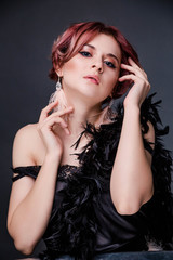 Beautiful retro woman from the roaring 20s is posing  on black background