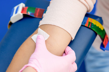 Nurse disinfecting arm skin.