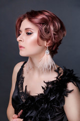 Beautiful retro woman from the roaring 20s is posing  on black background