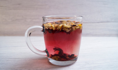 Fragrant fresh hot tea with fruits is poured into a glass mug on a light background. Tasty breakfast. Proper nutrition. Tea party.
