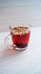 Fragrant fresh hot tea with fruits is poured into a glass mug on a light background. Tasty breakfast. Proper nutrition. Tea party.