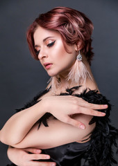 Beautiful retro woman from the roaring 20s is posing  on black background