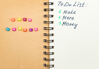 Side Hustle words made form multicolored square beads on spiral notebook cover. Concept image of...