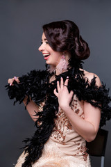 Portrait of happy brunette beautiful woman in boa from ostrich feathers . 20's years.