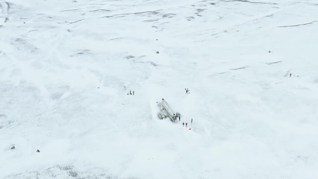 Aerial drone view of Solheimasandur dc3 Plane Crash in a Snowy Landscape in Iceland. Unrecognizable people