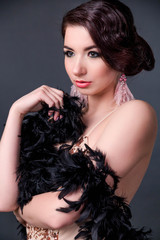 Beautiful retro woman from the roaring 20s is posing  on black background