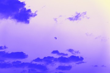 Moon behind the clouds, violet blue toned