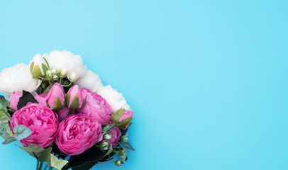 Pink and white flowers on blue background. Mother’s Day, Spring concept. Greeting, invitation card. Flat lay, top view style with copy space for your text.