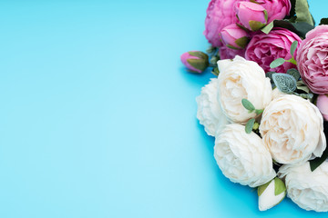 Pink and white flowers on blue background. Mother’s Day, Spring concept. Greeting, invitation card. Top view style with copy space for your text.