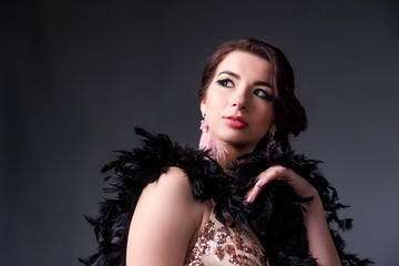 Beautiful retro woman from the roaring 20s is posing  on black background
