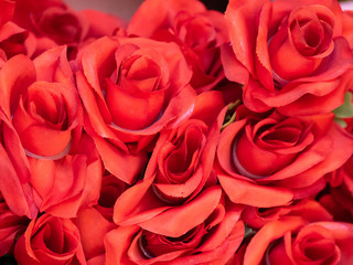 Close up imitation or artificial red rose flower background. Selective focus.