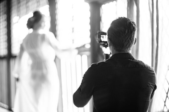 silhouettes of wedding videographer and bride