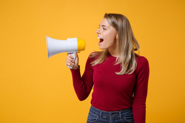 Young blonde woman girl in casual clothes posing isolated on yellow orange background studio portrait. People sincere emotions lifestyle concept. Mock up copy space. Scream in megaphone looking aside.