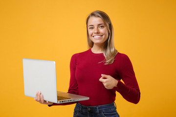 Smiling beautiful young blonde woman girl in casual clothes posing isolated on yellow orange wall...
