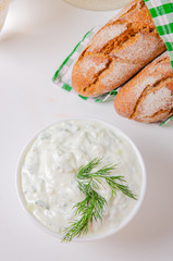 Greek appetizer (salad) - tzatziki. Yogurt, fresh cucumbers and dark (buckwheat) bread (baguette).