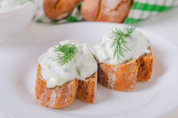 Greek appetizer (salad) - tzatziki. Yogurt, fresh cucumbers and dark (buckwheat) bread (baguette).