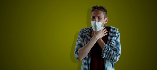 male person holding a throat while choking and can not breathe, isolated against the wall,...