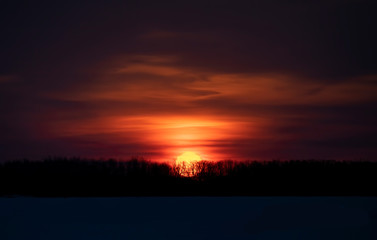 Fototapeta na wymiar A winter sunrise with a red sky and clouds in Ottawa, Canada
